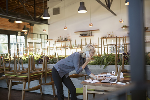 cafe owner doing accounts on phone