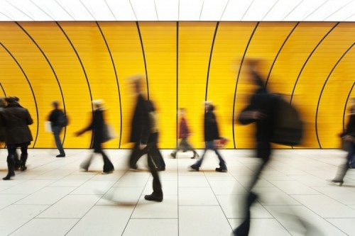 Commuters walking through a yellow tunnel