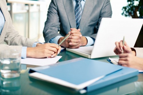 A business meeting, laptop and documents on table
